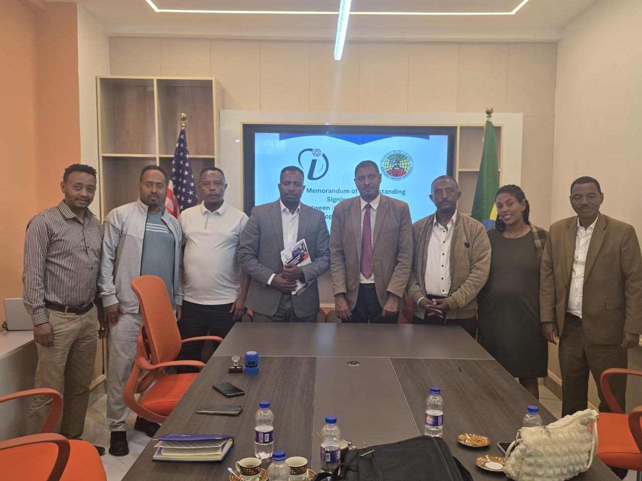 Representatives holding signed documents after the MoU ceremony